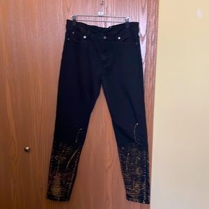 Stylish black jeans with copper color design paint pattern on legs